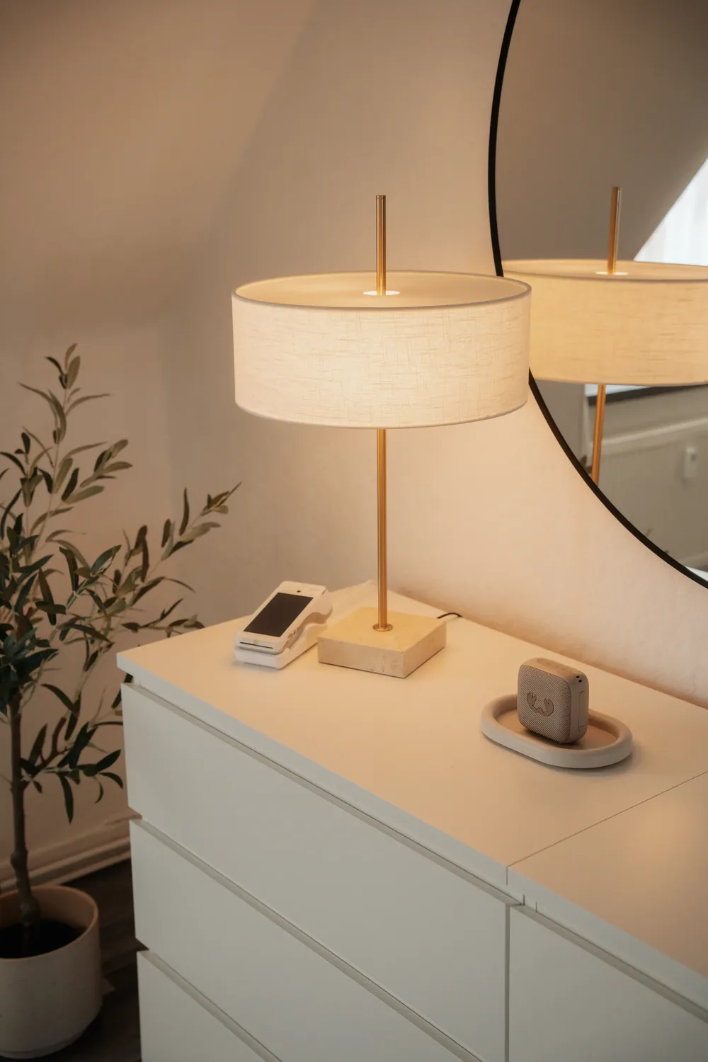 Tischlampe und Kartenzahlungsgerät auf der weißen Kommode im Studio