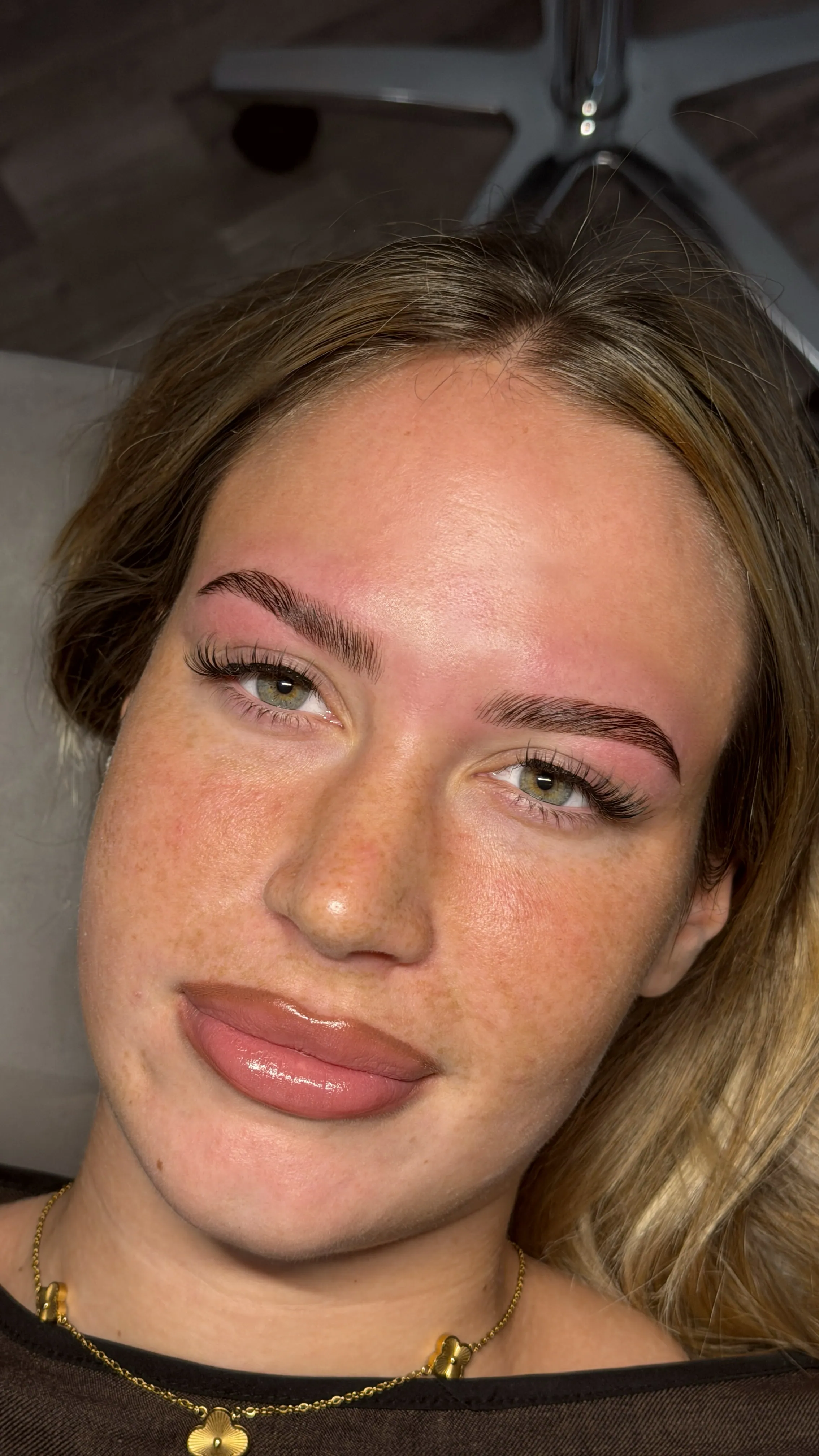 Strahlende Kundin mit gestylten Brauen und gelifteten Wimpern